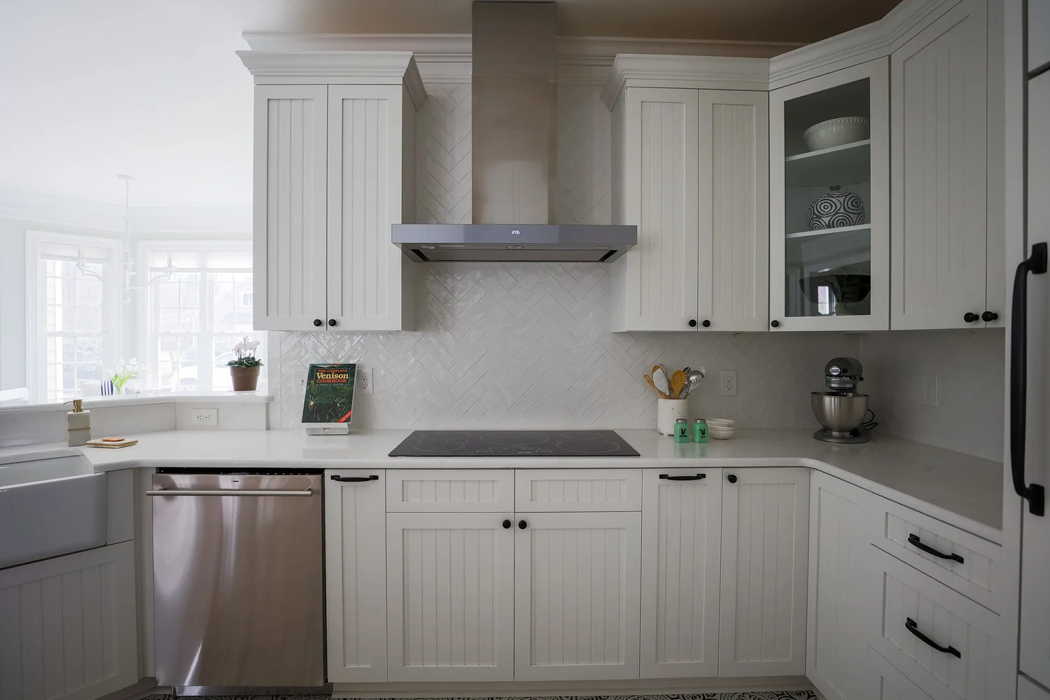 Bright white Toano kitchen remodeled by VanFleet Homes with custom cabinetry, patterned flooring, and a compact island