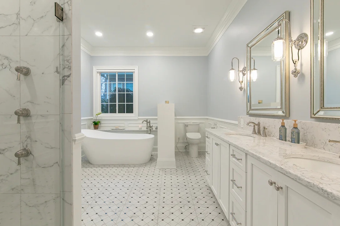 VanFleet Homes bathroom remodel with a freestanding tub, marble-look shower, and white double vanity