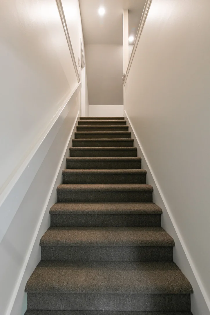 Completed carpeted staircase leading to the finished attic gym