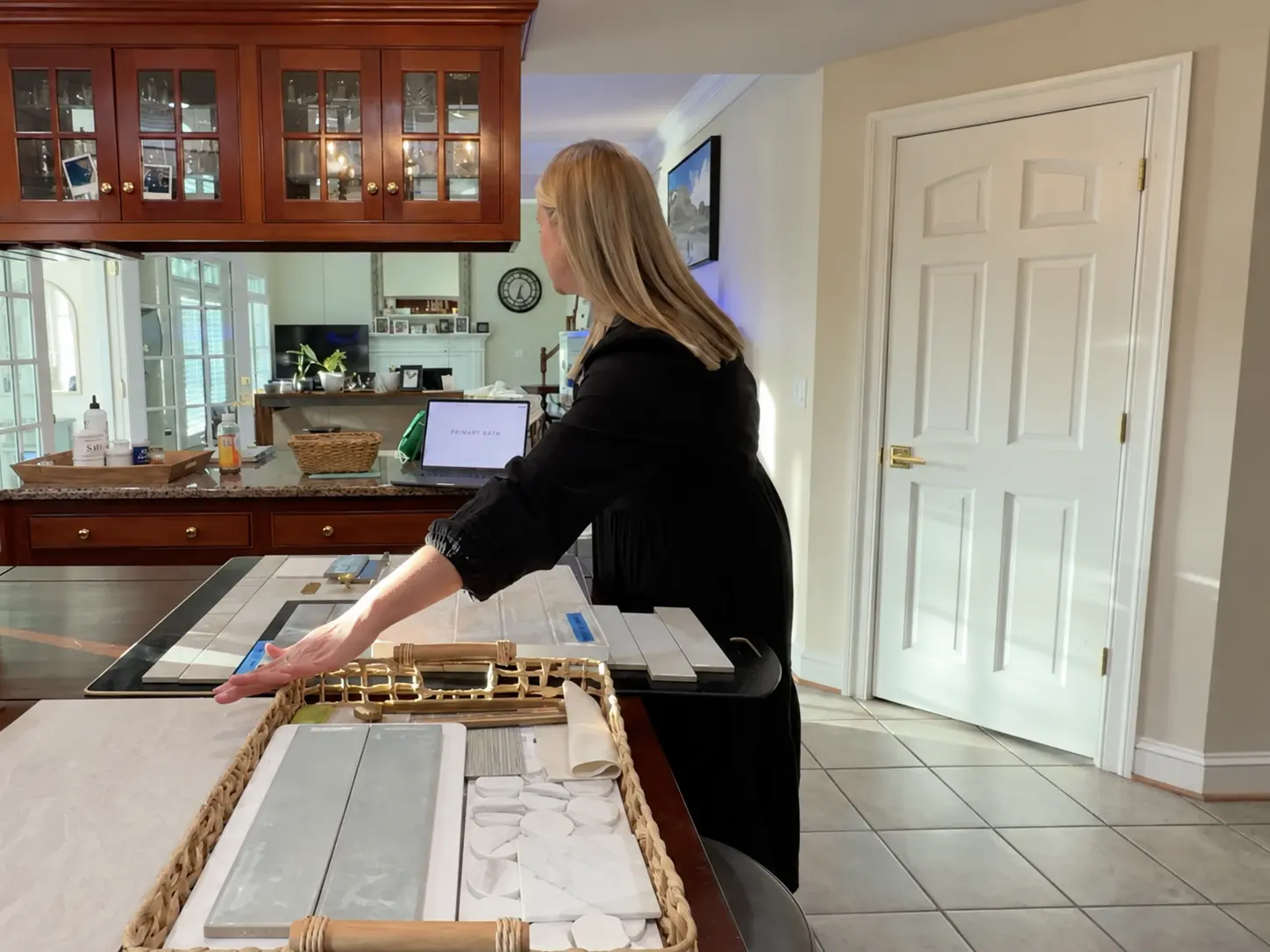 Bree Harris presenting design selections with tile, hardware, and finish samples on the table