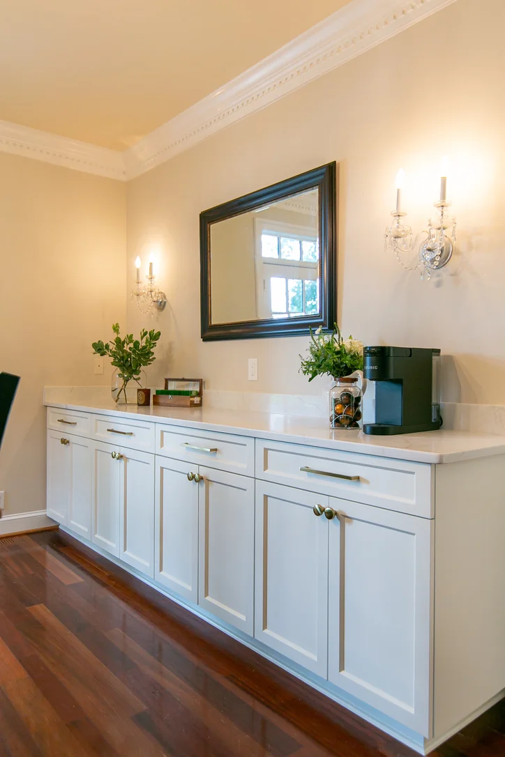 Finished Ford’s Colony dining room with white built-in cabinets, light countertop, brass-toned hardware, and a coffee station