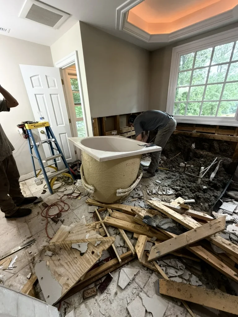 Removal of the original built-in tub and tiled platform during primary bathroom demolition