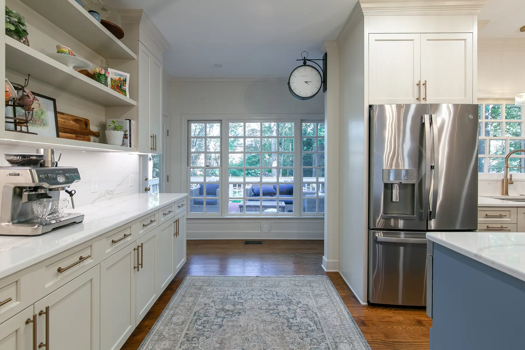 Long cabinet and countertop run with integrated refrigerator, coffee bar, open shelving, and full-height backsplash in a Kingsmill kitchen