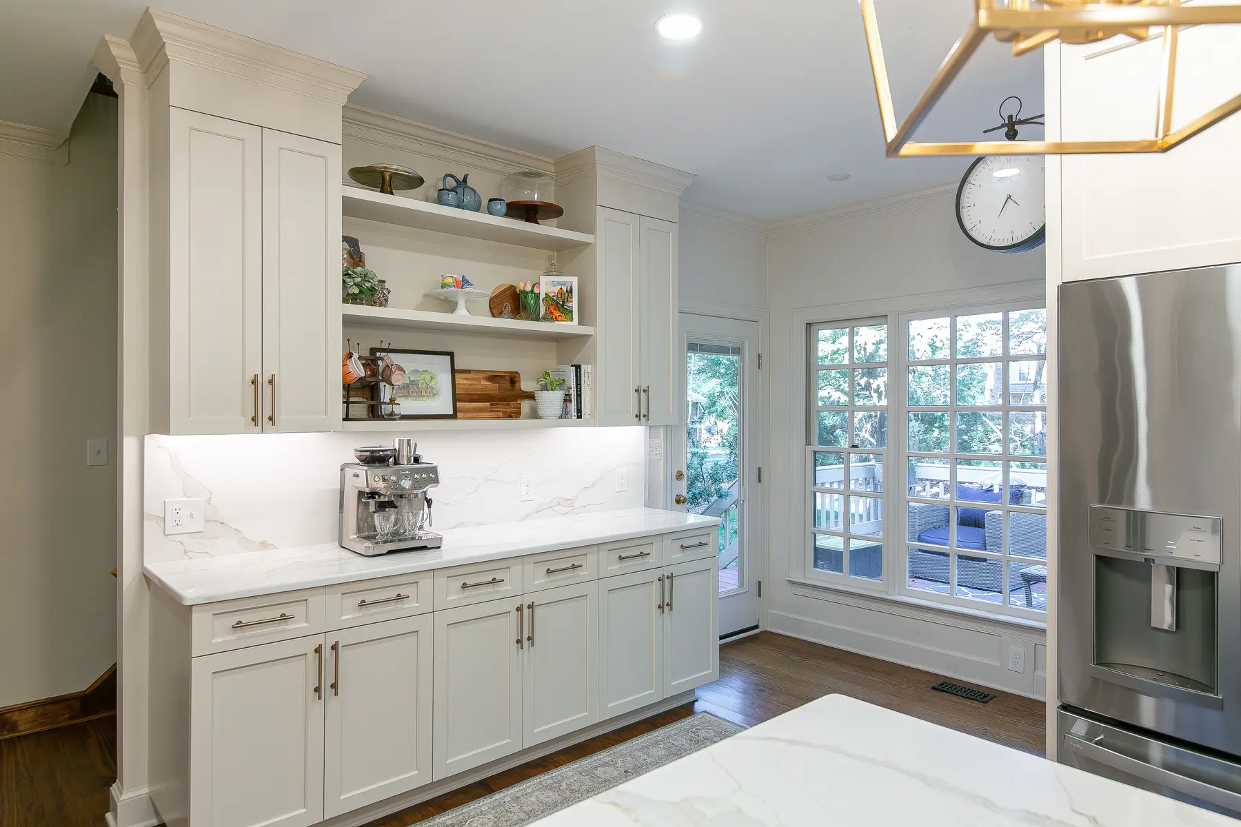 Coffee bar, open shelving, refrigerator surround, and bright garden doors in a completed Kingsmill kitchen