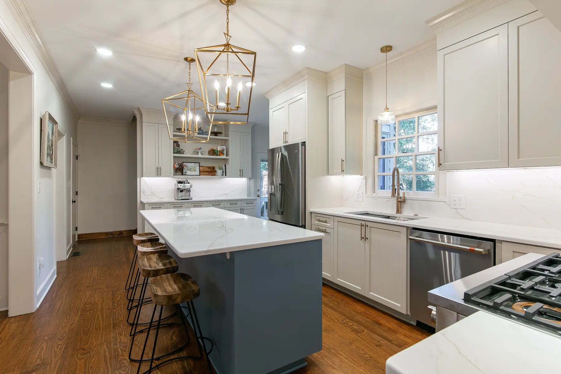 Side overview of a Kingsmill kitchen remodel showing the blue island, white stone surfaces, custom storage, and adjoining dining room